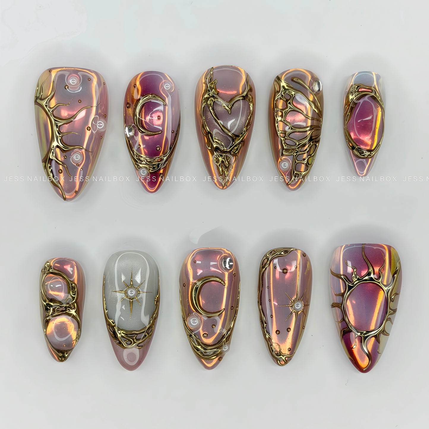 Iridescent purple and pink aurora chrome press-on nails featuring 3D liquid gold sun, moon, and heart filigree art by Jess Nailbox.