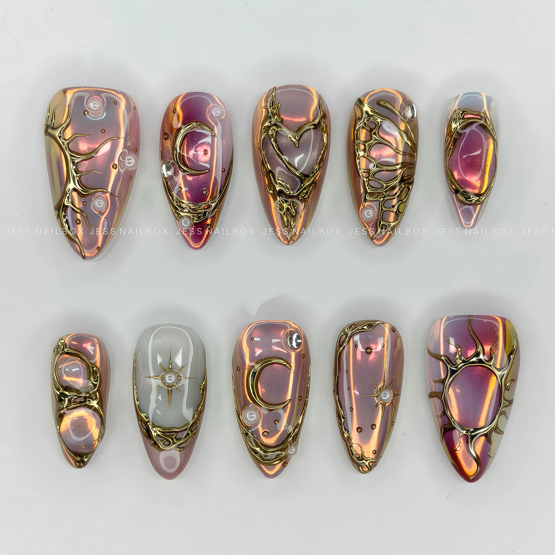 Iridescent purple and pink aurora chrome press-on nails featuring 3D liquid gold sun, moon, and heart filigree art by Jess Nailbox.