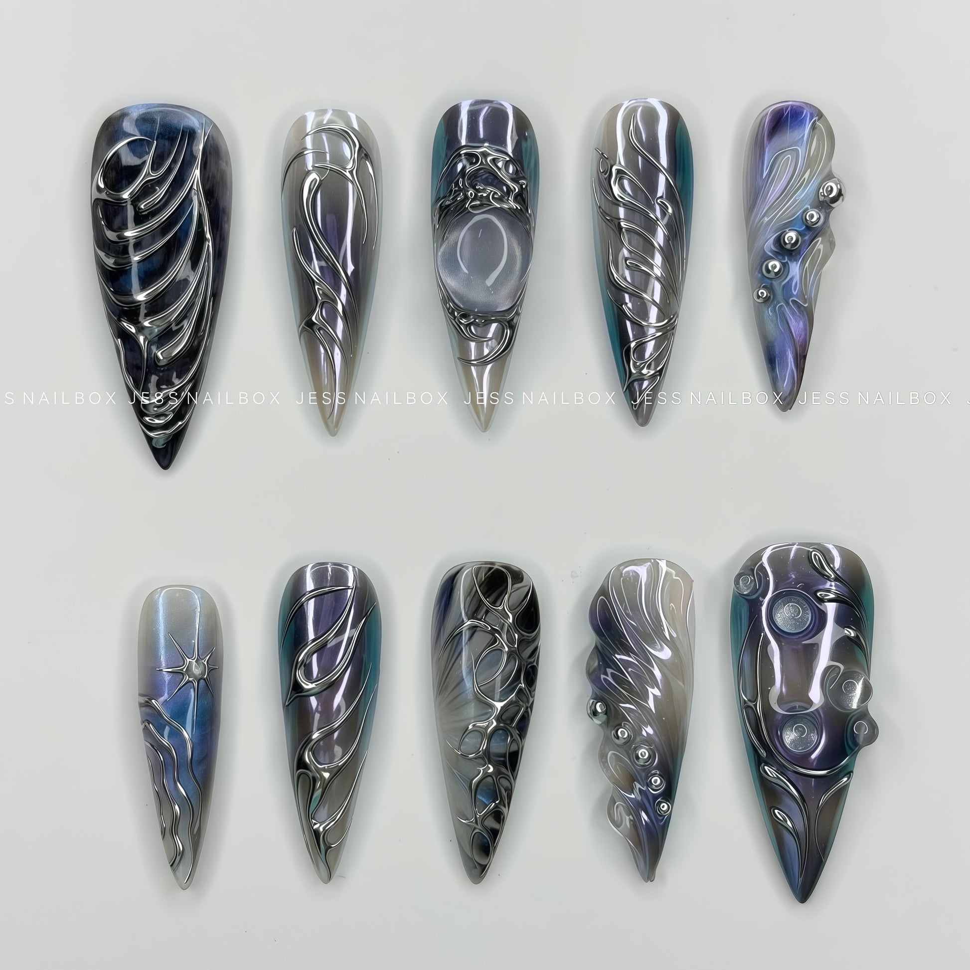Handmade stiletto press-on nails featuring a deep nebula cat-eye base with intense 3D silver liquid metal abstract swirls and bio-inspired bead chains.