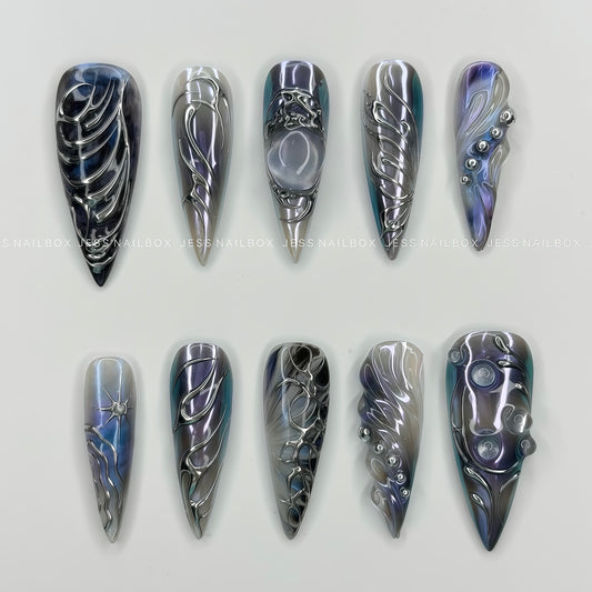 Handmade stiletto press-on nails featuring a deep nebula cat-eye base with intense 3D silver liquid metal abstract swirls and bio-inspired bead chains.