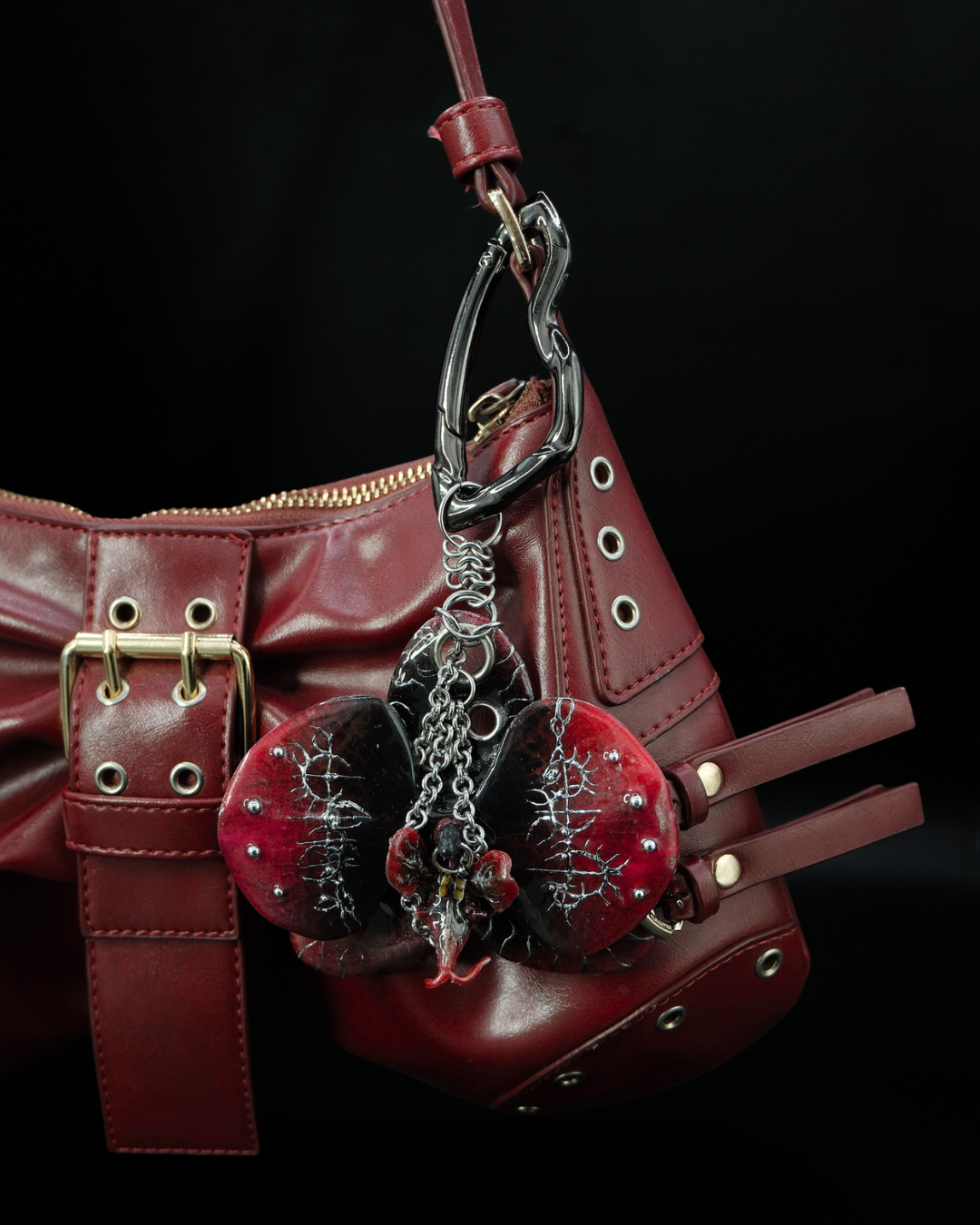 Red Voltage - Crimson and Black Resin Orchid Charm Styled as a Statement Accessory on a Red Leather Bag
